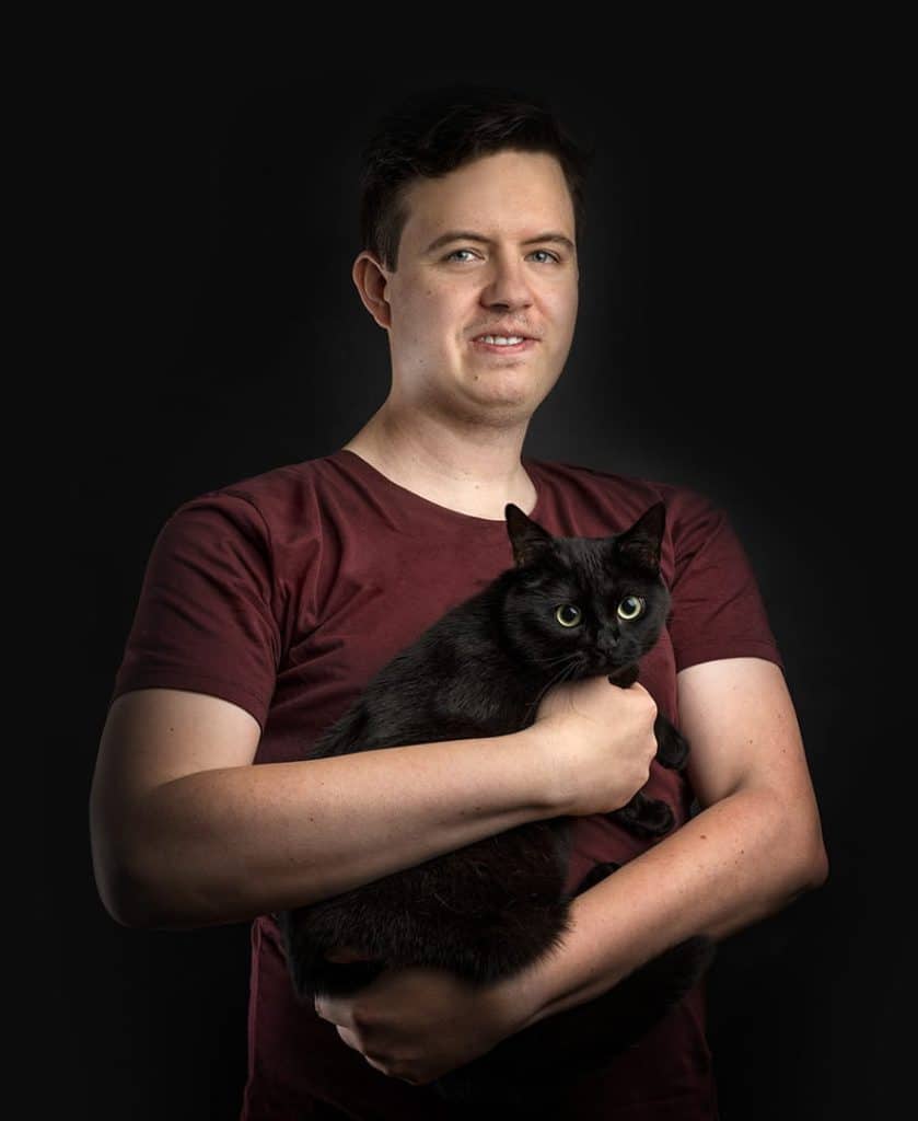 Man named Jimmy posing with black cat
